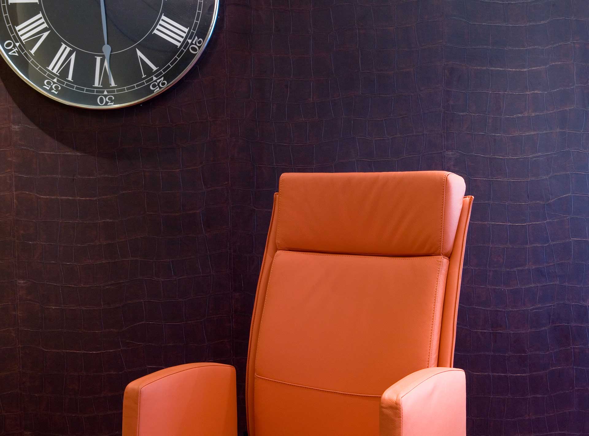Chaise orange et horloge pour des bureaux dans le quartier des banques à Genève. Réalisation ID Interior Design par Anne-Laure Ferry.-Adam, architecte d'intérieur.
