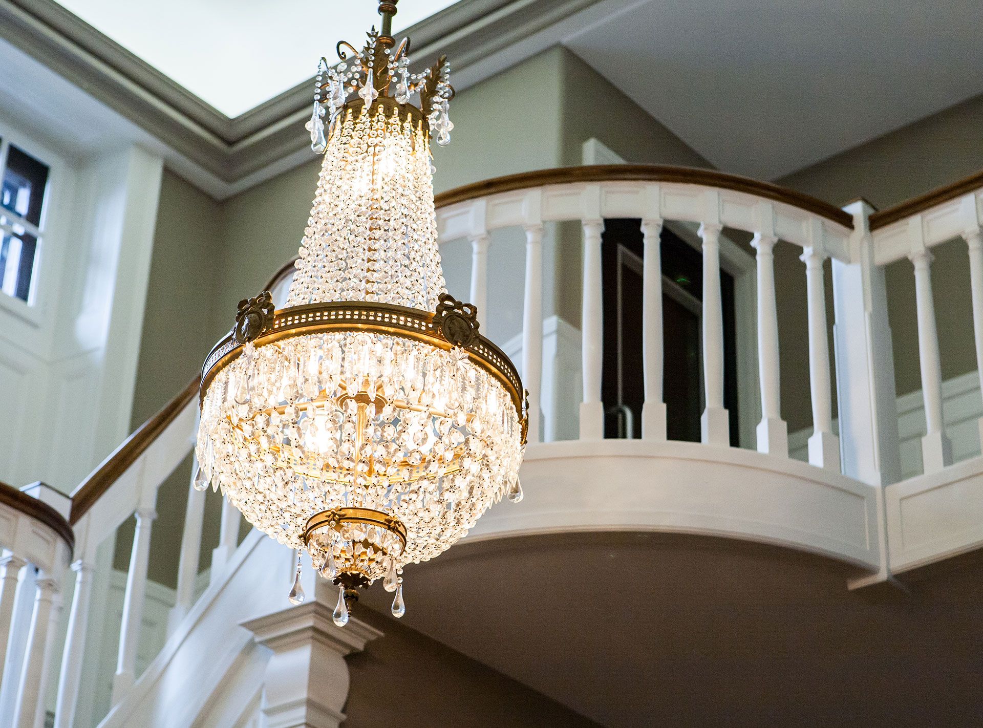 Lustre devant escalier d'une maison de maitre à Conches. Réalisation Anne-Laure Ferry-Adam d'ID intérior design, architecte d'intérieur à Genève.