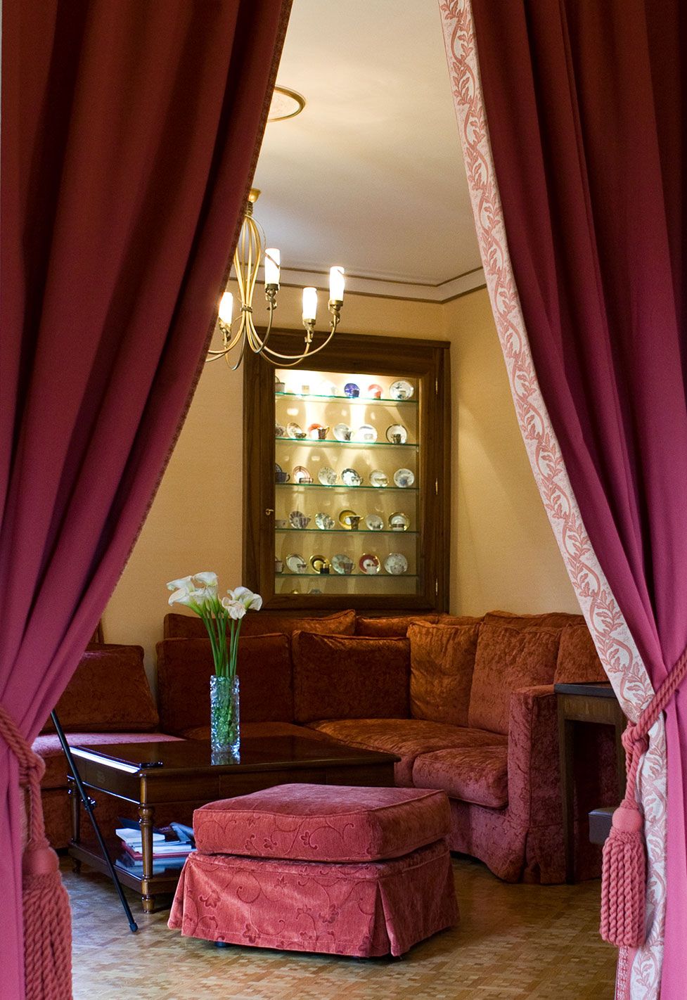 Vue du salon à travers l'embrasure des rideaux de cette maison ancienne à Carouge. Réalisation par Anne-Laure Ferry-Adam, architecte d'intérieur à Genève.