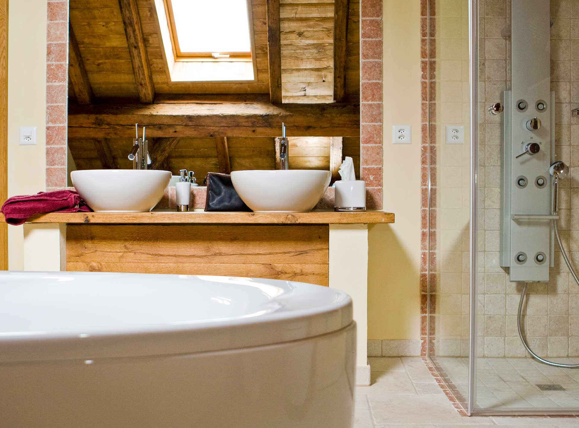 Salle de bains avec vasques, douche et baignoire de la ferme de Founex rénovée en appartement par Anne-Laure Ferry-Adam, architecte d'intérieur à Genève